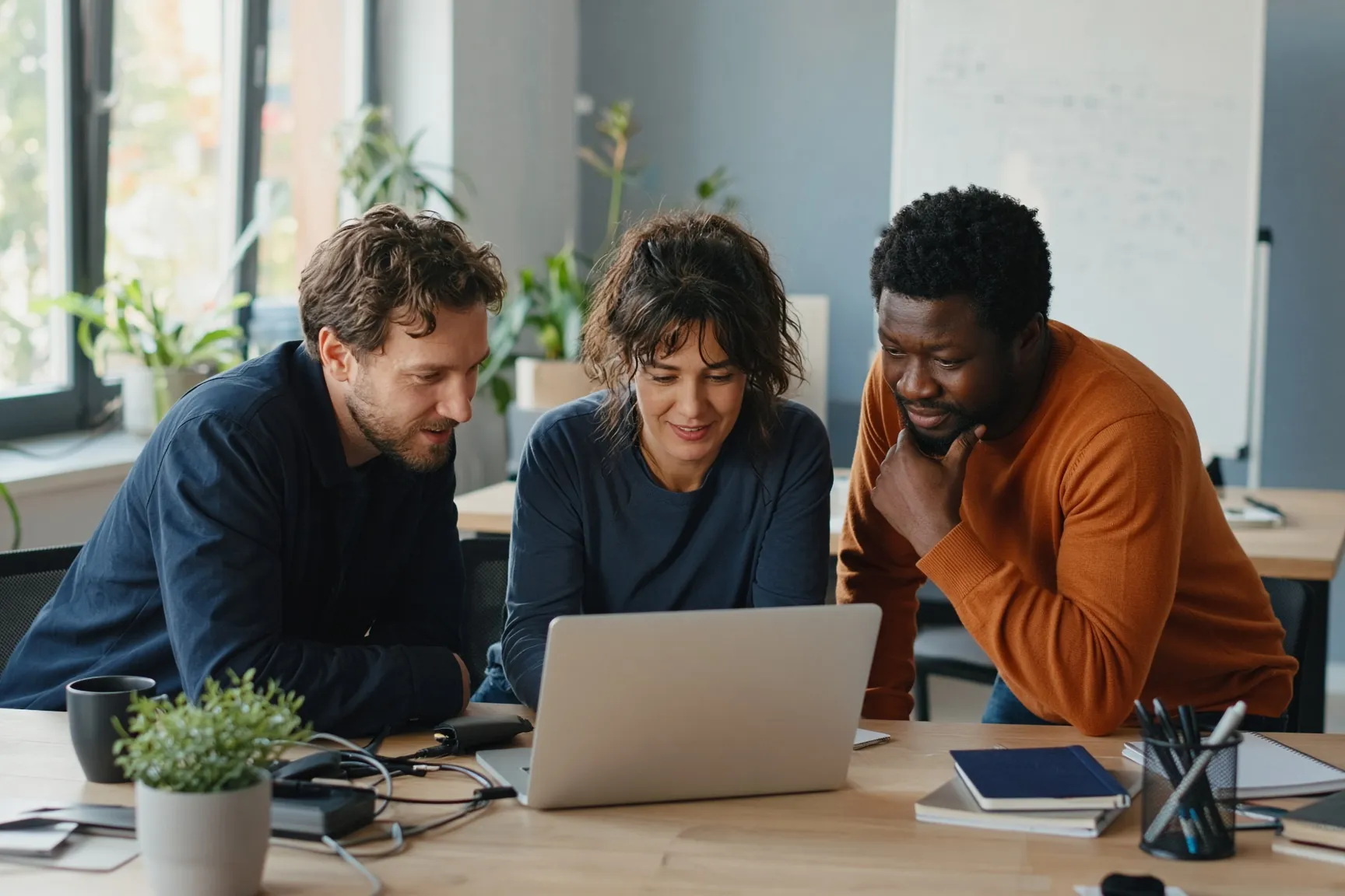 Three Cole Tech team members reviewing a client's setup together on a laptop